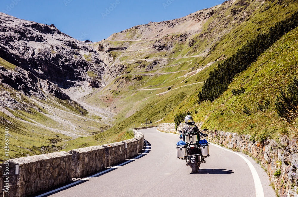 Fototapeta premium Famous Passo Dello Stelvio Road in Swiss - Italy border. Favourite place for all bike riders. Alone biker on the top.