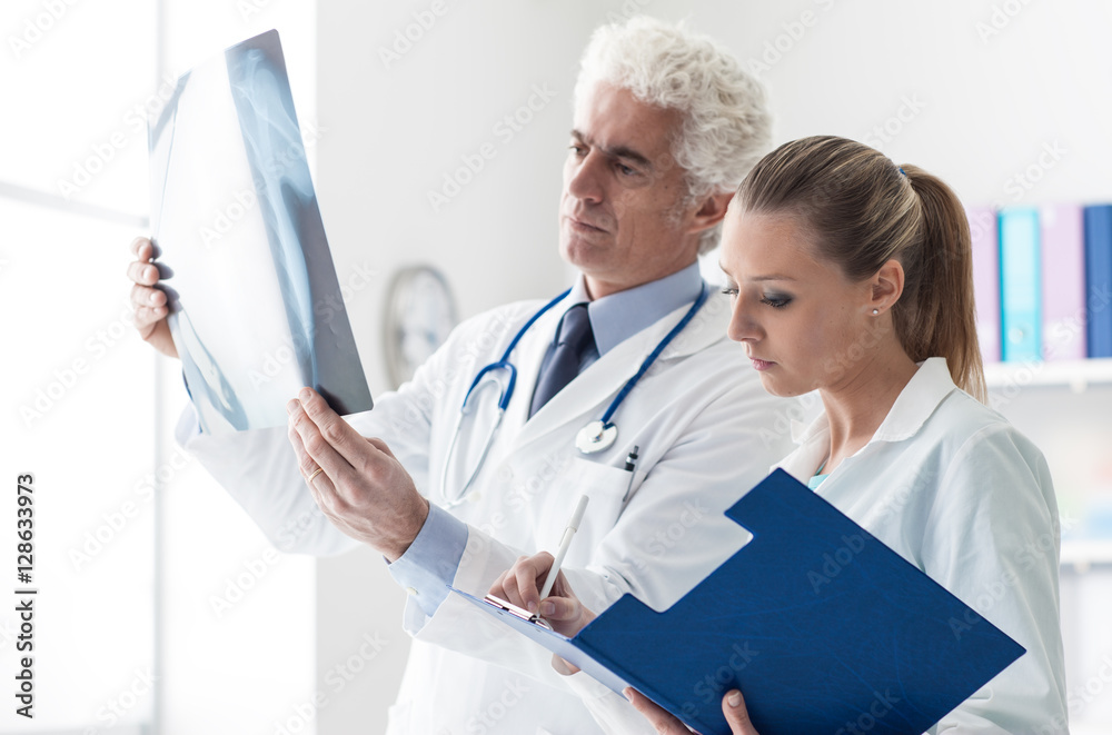 Medical team examining a patient's x-ray Medical team examining a patient's x-ray