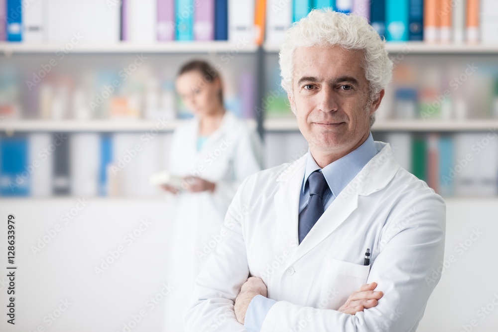 Confident doctor posing in his office