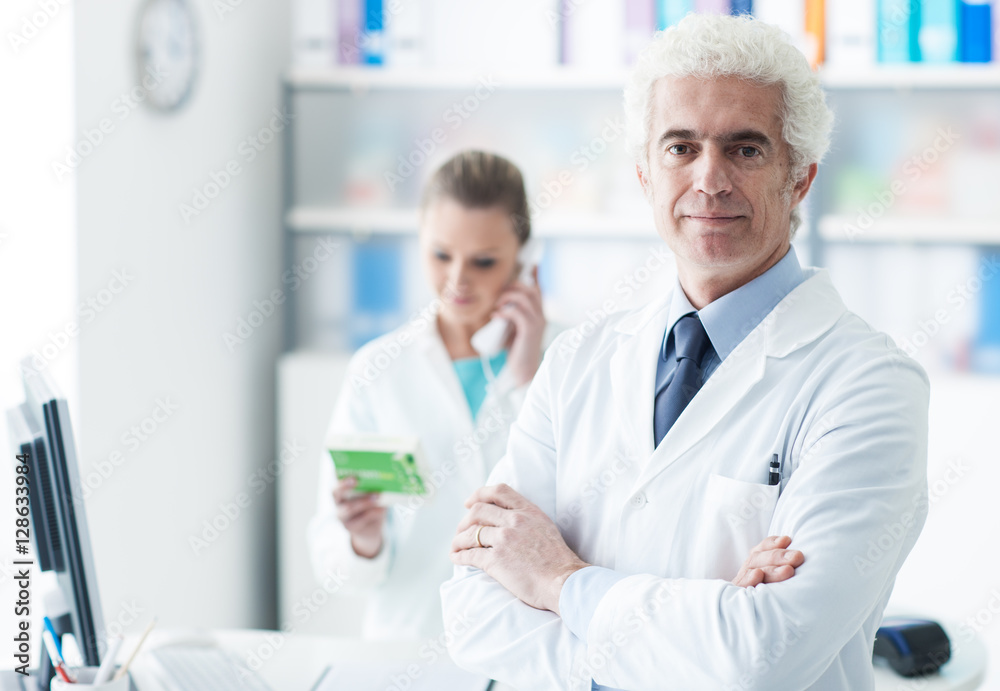 A doctor with his assistant in the office A doctor with his assistant in the office