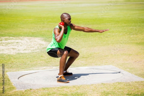Male athlete preparing to throw shot put ball