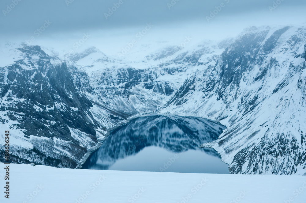 Obraz premium Beautiful clear scenery with blue water in clean lake and big mountains covered by snow. Original winter wallpaper.