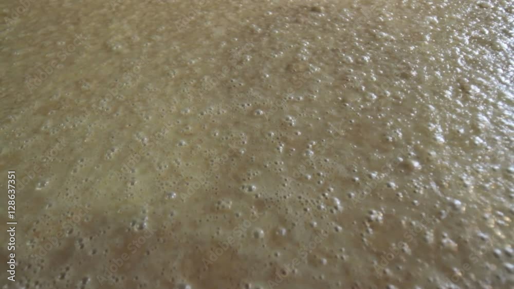 Close up of bubbles from fermenting corn mash in Kentucky bourbon distillery.