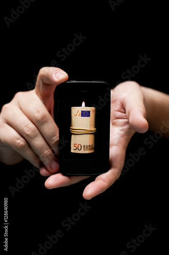 Hands Holding Smartphone, showing   fifty Euro bill on fire