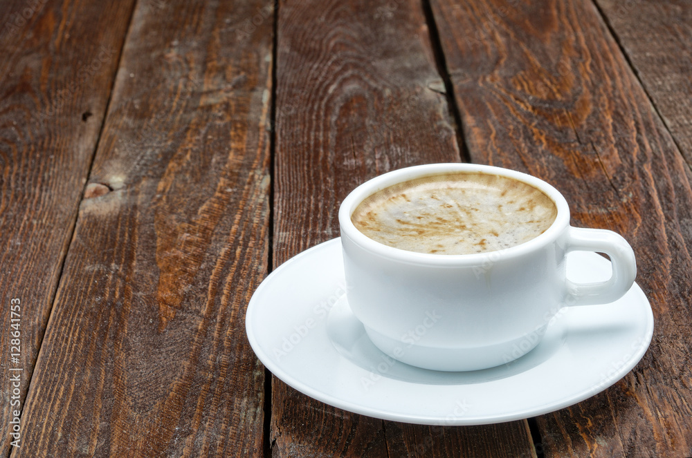 Fototapeta premium White coffee cup with foam on dark wood table