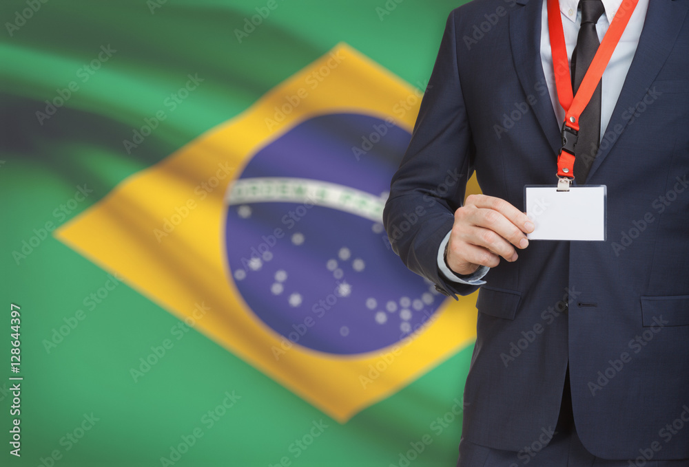 Businessman holding name card badge on a lanyard with a national flag on background - Brazil Businessman holding name card badge on a lanyard with a national flag on background - Brazil