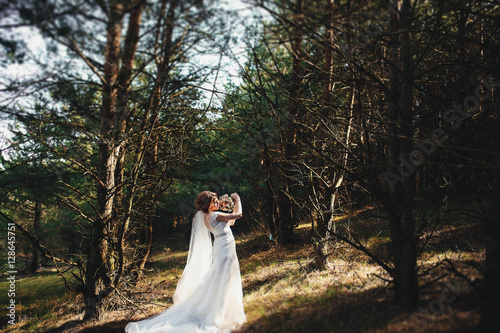 very beautiful bride in a white dress standing in a forest