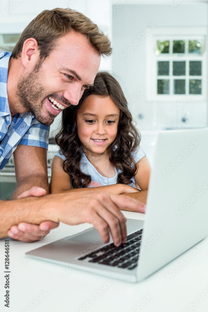 Man with daughter using laptop computer at home Man with daughter using laptop computer at home