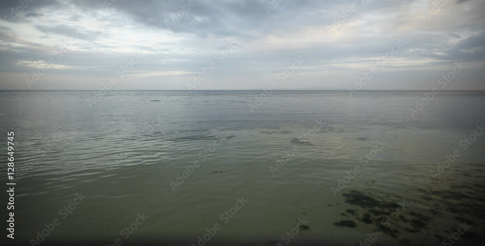 ocean landscape with different colours of water and cloudy sky