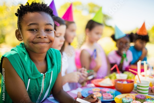Cute boy smiling in front of other children 