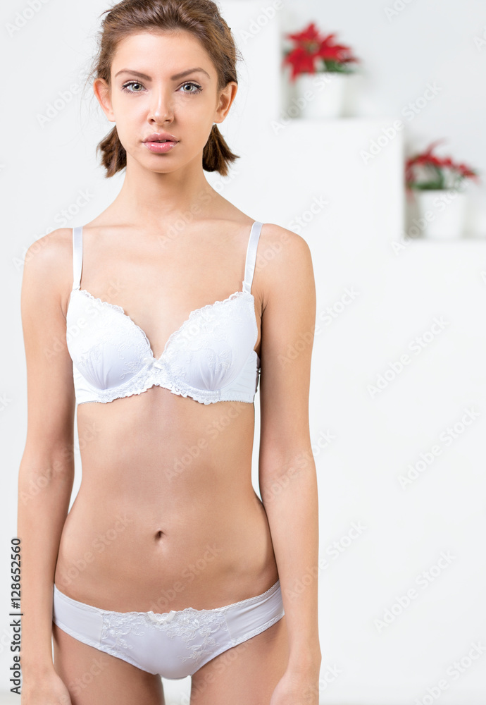 Beautiful slim woman wearing white lingerie. Studio shot of young seductive woman . Beautiful slim woman wearing white lingerie. Studio shot of young seductive woman .