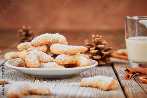 Vanillekipferl with powder sugar on wooden table