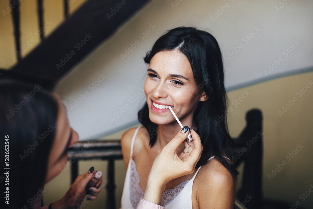 Fototapeta premium makeup artist doing makeup for beautiful and young girl