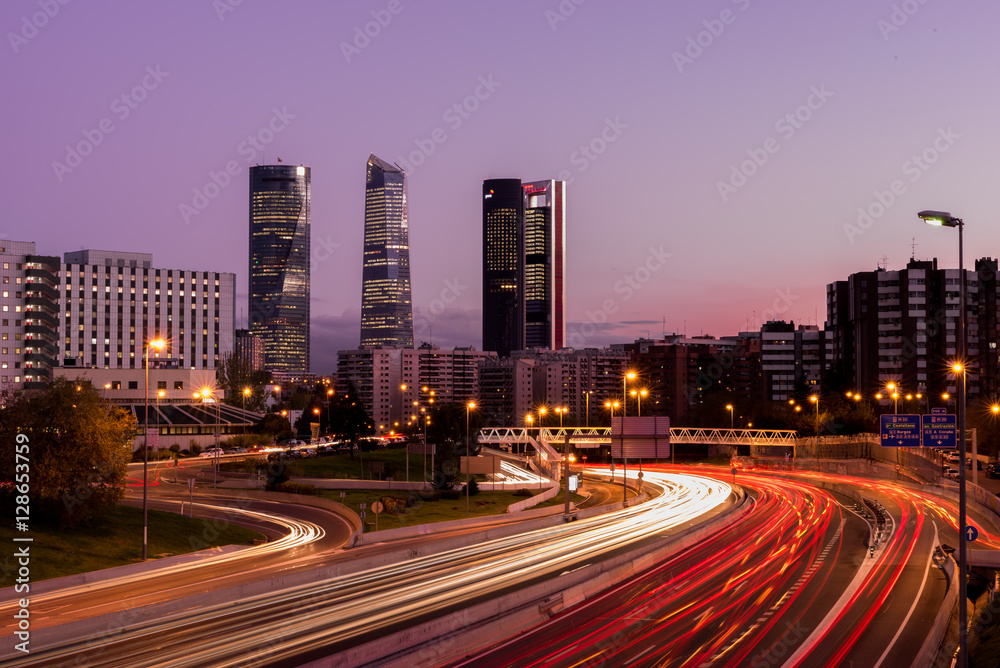 Atardecer de Madrid con los rascacielos y las luces de la carretera