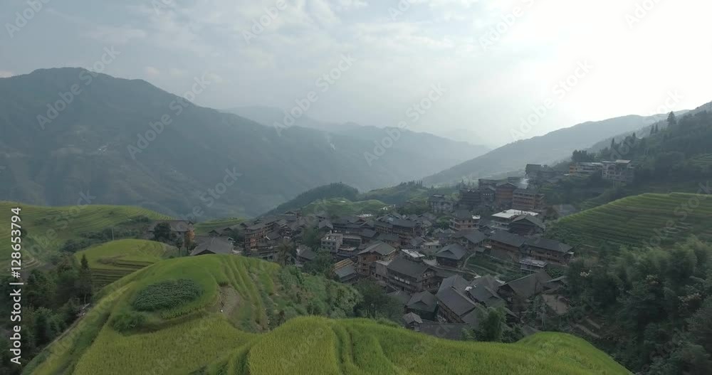 Beautiful 4k aerial shot of Longsheng Village and Terraced Rice Field at Morning - Longsheng, Guangxi province, China. Rural view, agriculture, scenic area.Top view of small wooden traditional houses. Beautiful 4k aerial shot of Longsheng Village and Terraced Rice Field at Morning - Longsheng, Guangxi province, China. Rural view, agriculture, scenic area.Top view of small wooden traditional houses.