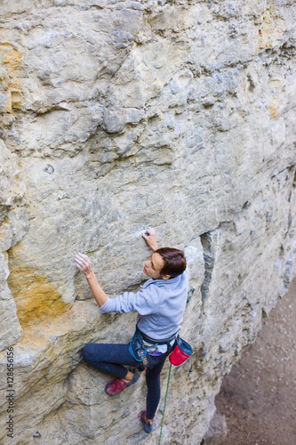 Fototapeta Naklejka Na Ścianę i Meble -  The girl climbs the rock.