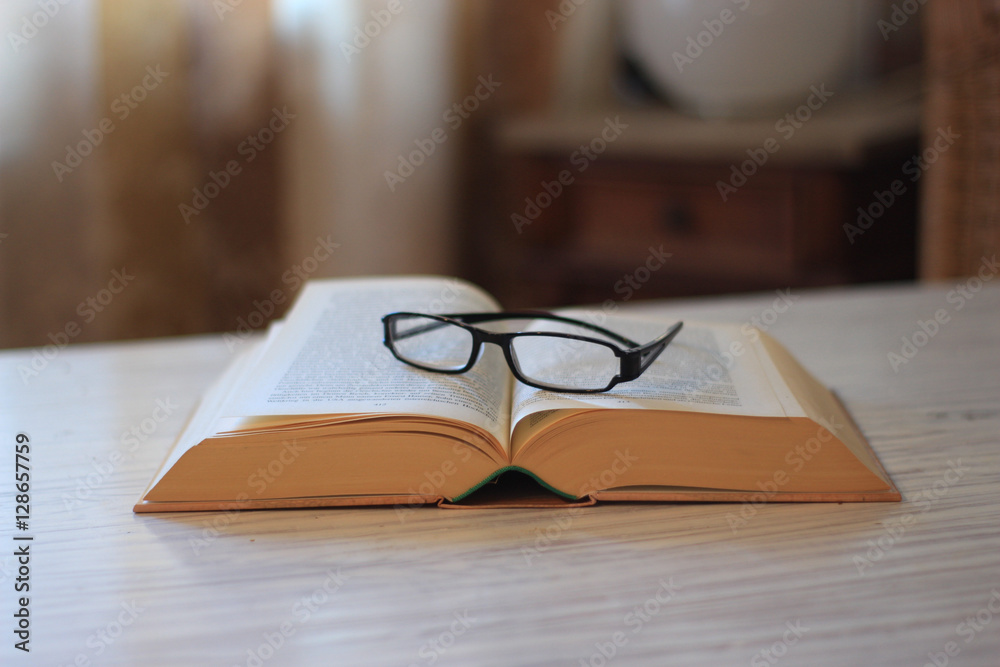 Ein aufgeschlagenes Buch mit Lesebrille Ein aufgeschlagenes Buch mit Lesebrille