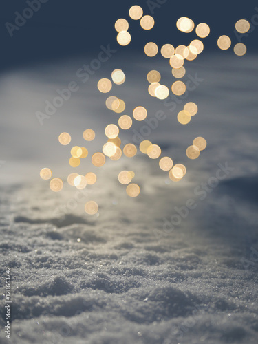 Moody glow of Christmas lights on fresh evening snow, background, copyspace