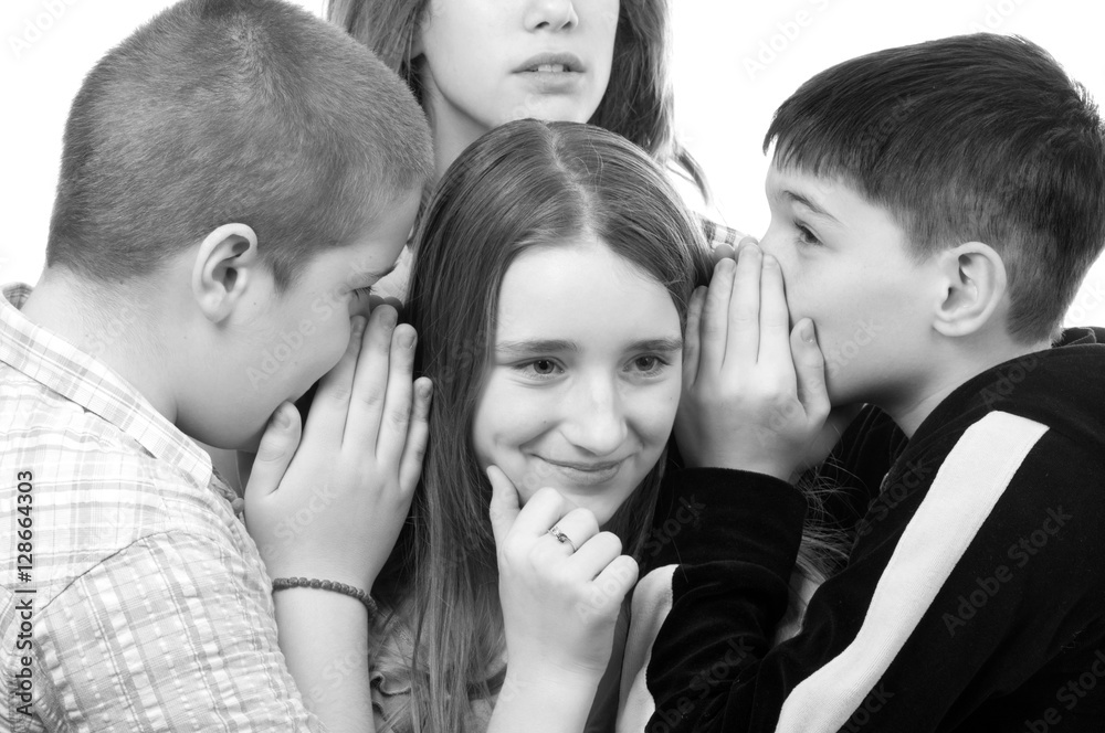 Two teenage boys and a girl gossiping about the second girl isolated on white Two teenage boys and a girl gossiping about the second girl isolated on white