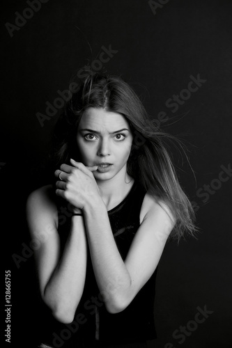 A young girl with long hair. Sensual finger around the lips . BW