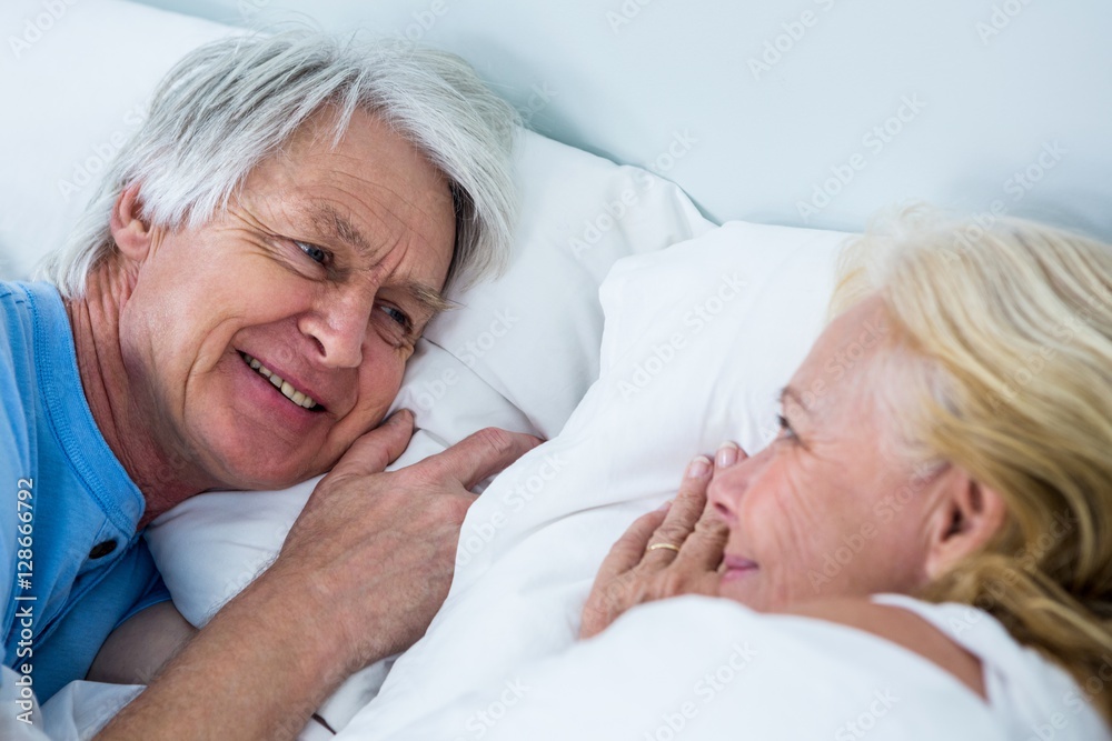 Close-up of smiling senior couple sleeping on bed Close-up of smiling senior couple sleeping on bed