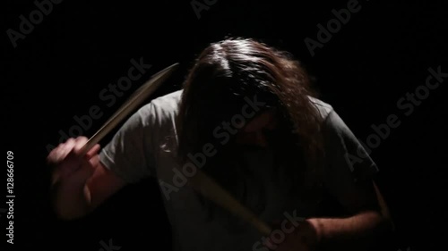 drummer playing on drums in a dark room photo