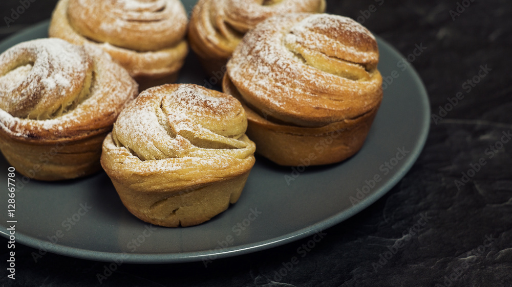 Homemade pastries cruffins, muffin with sugar powder, on dark background, selective focuse close up Homemade pastries cruffins, muffin with sugar powder, on dark background, selective focuse close up