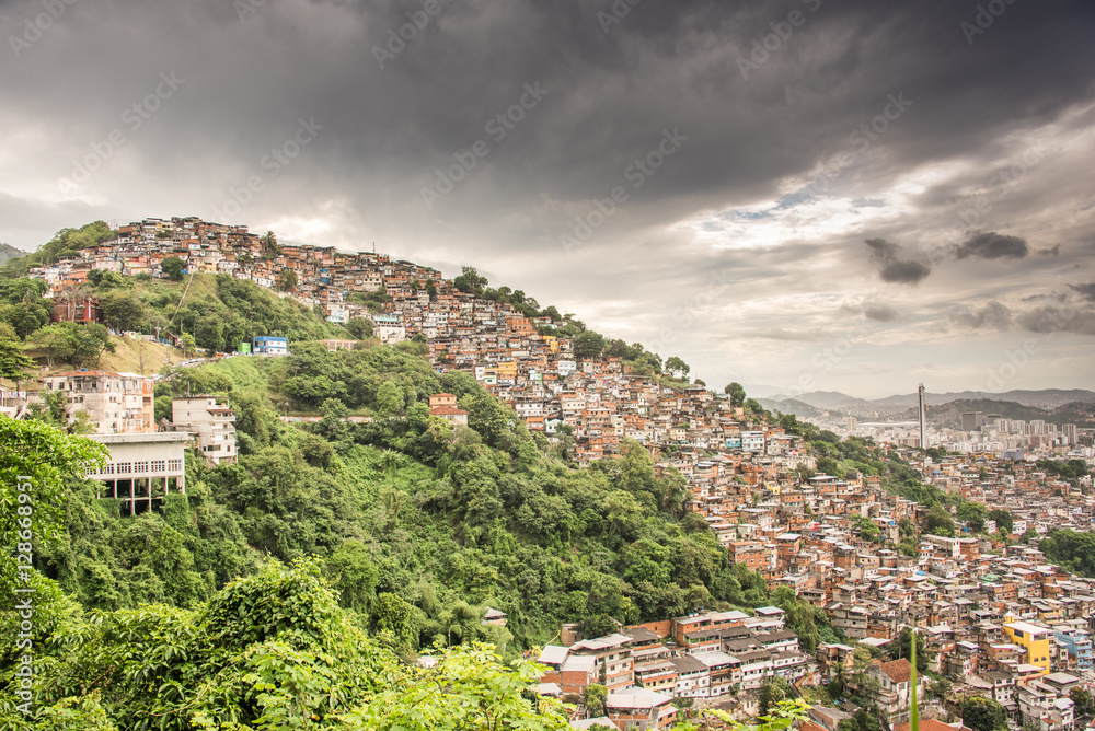 View of Rio de Janeiro Slum, favela Morro dos Prazeres on mountains with dark grey sky, Brazil