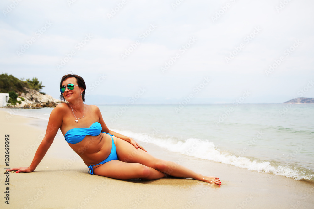 Woman in blue bikini relaxing on the beach