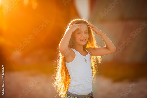 Closeup of a beautiful girl with a sunset behind her