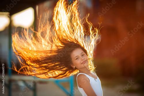Closeup of a beautiful girl with a sunset behind her