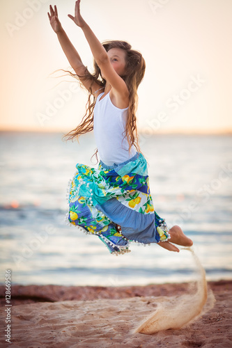 Adorable happy smiling little girl on beach vacation