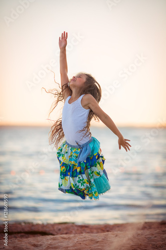 Adorable happy smiling little girl on beach vacation
