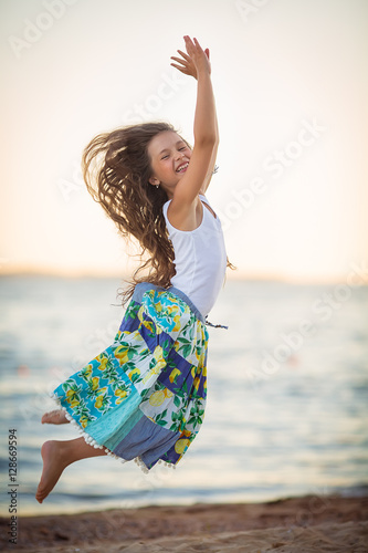 Adorable happy smiling little girl on beach vacation