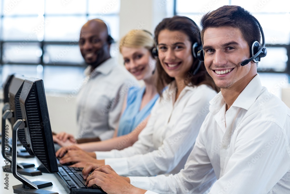 Team of colleagues sitting at their desk with headset Team of colleagues sitting at their desk with headset