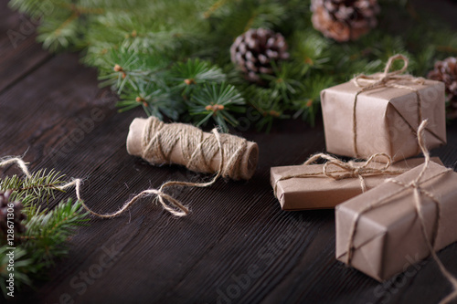 Christmas composition on wooden background with tree, pine cones and cardboard boxes