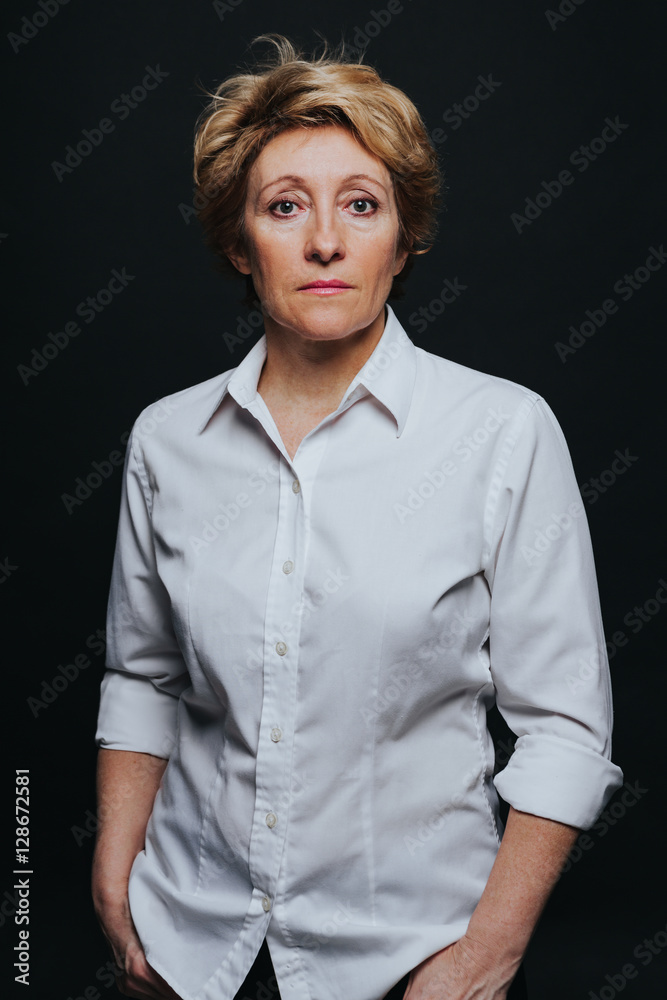 Half length portrait of middle aged woman posing in casual outfit isolated on black background. Half length portrait of middle aged woman posing in casual outfit isolated on black background.