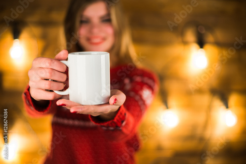 beautiful young woman with cup of coffee on the background of lights