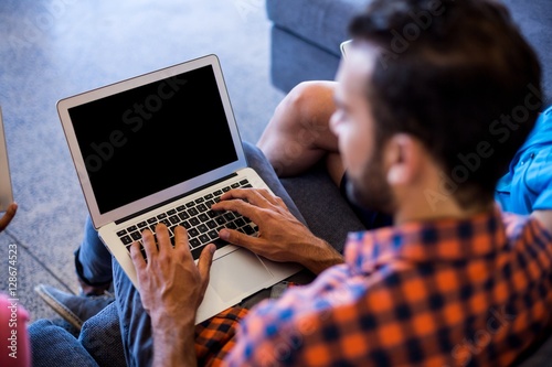 Man siting on sofa using laptop