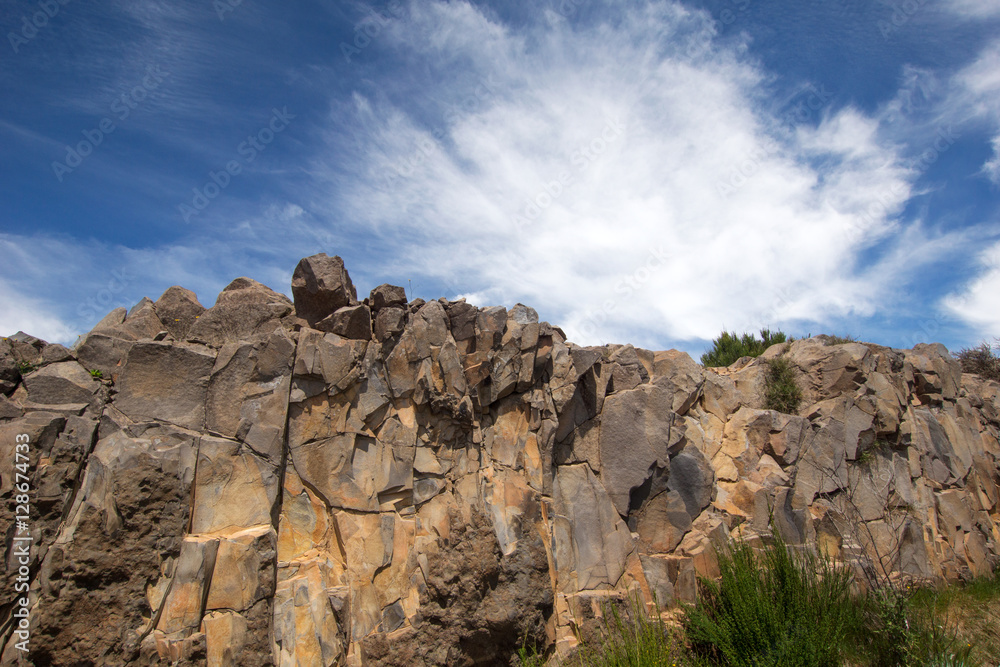 Fototapeta premium Natural stone wall with clouds and sky background