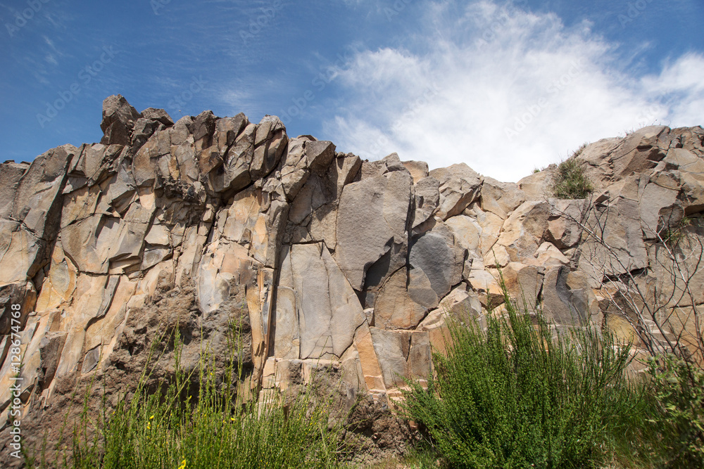 Natural stone wall with clouds and sky background