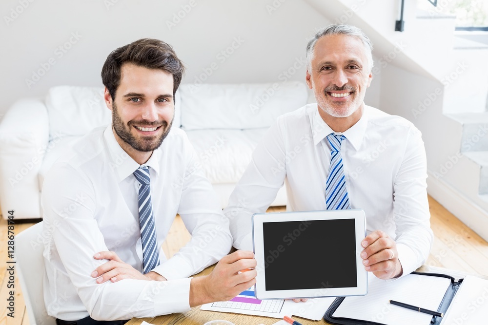 Businessmen holding digital tablet in office Businessmen holding digital tablet in office