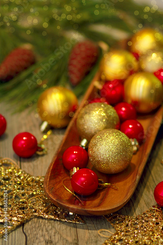 red green and gold Christmas balls on wooden tray, golden stars