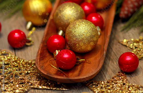red green and gold Christmas balls on wooden tray, golden stars