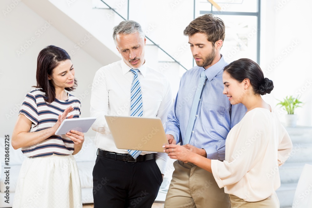 Business people interacting using digital tablet and laptop Business people interacting using digital tablet and laptop