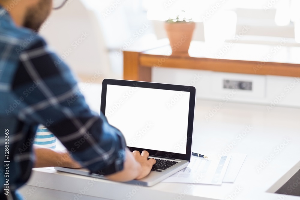 Man using laptop at his desk Man using laptop at his desk