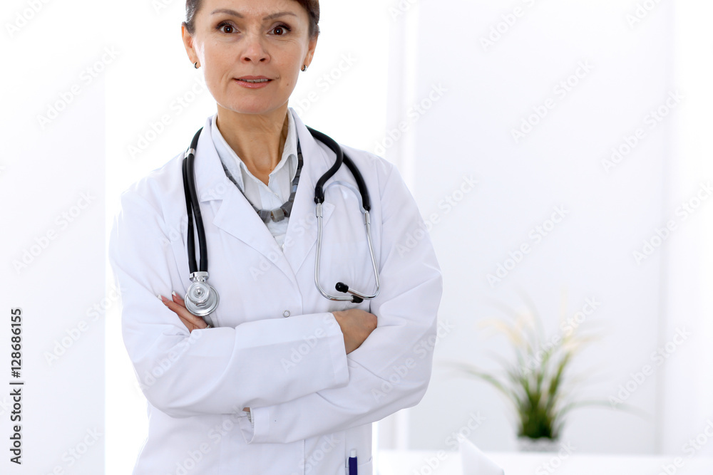 Happy female doctor standing in hospital. Medicine and health care concept. Happy female doctor standing in hospital. Medicine and health care concept.