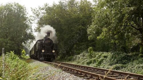 steam engine train locomotive driving on railroad tracks. nostalgic transportation background.