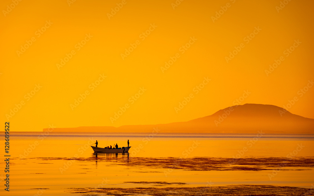 Silhouette in the golden sunrise of bait fishing boat panga off Loreto on  the Sea of Cortez with Coronado Island on the horizon Stock Photo