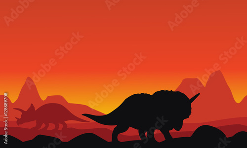Silhouette of dinosaur triceratops with mountain backgrounds